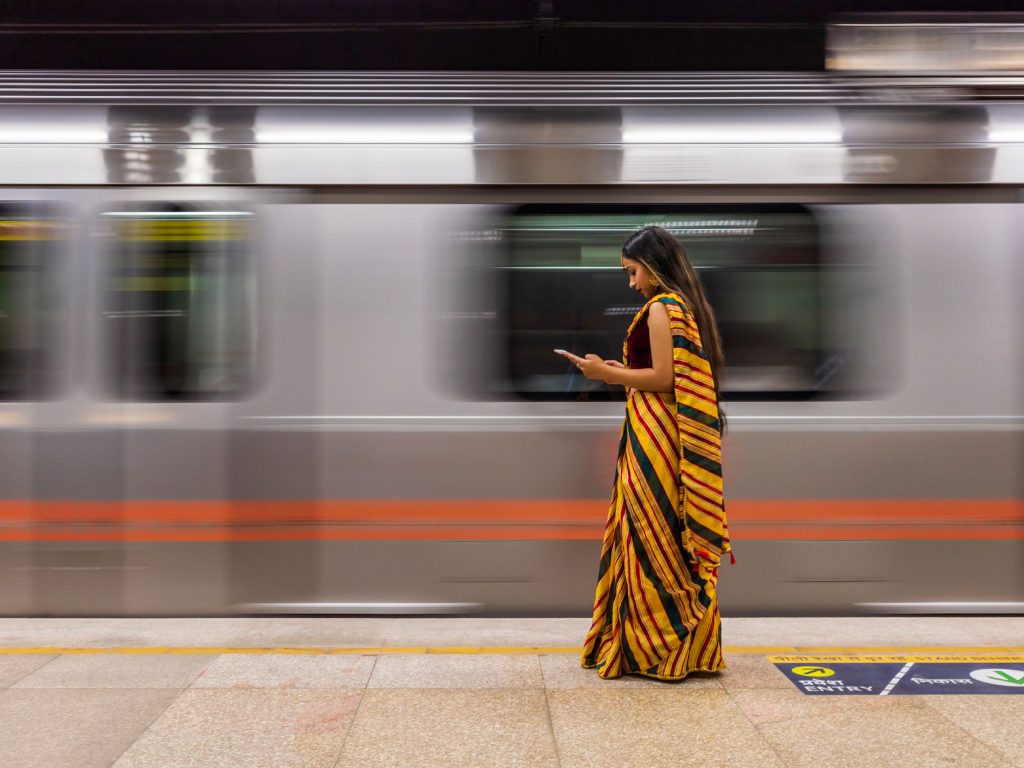 Indian girl using a digital tablet at metro station.